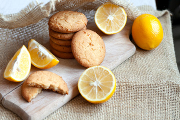lemon gingerbread cookies lie on a wooden board on a rustic table, still life of fresh biscuits with citrus, copy space