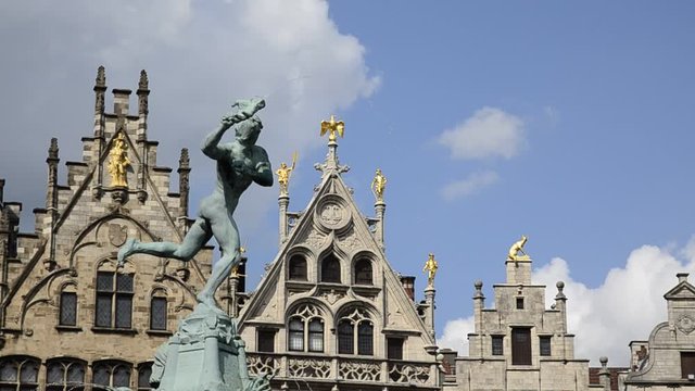 Antwerp, Flanders,Belgium. August 2019. The town hall square in the center has a sculptural fountain. Detail of the fountain and the top of the buildings in the background. Blue sky with white clouds.