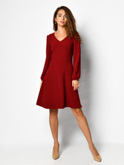 Young beautiful woman posing in new fashion casual red winter dress happy smiling walking on white full body