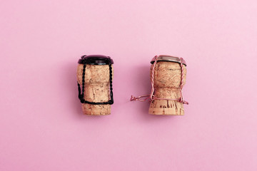 Girl and boy characters from champagne corks and muselets together on pink colored background. Concept for Valentines Day on topic of relations between man and woman.