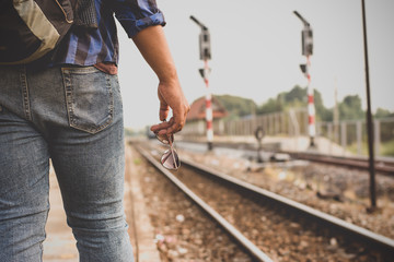Fototapeta premium The male tourists are standing at the railway station, tourism and transportation.
