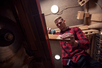 Obraz na płótnie Canvas Carpenter working with drill in his garage