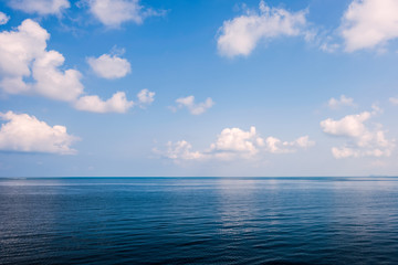 Naklejka na ściany i meble Sea on blue sky with cloud background