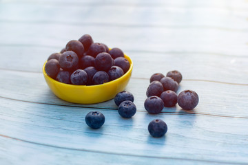 Superfood berries: blueberries in a bowl on a wooden background.