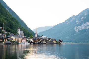 Scenic view of famous Hallstatt lakeside town reflecting in Hallstattersee lake in the Austrian Alps on a sunny day in summer, Salzkammergut region, Austria
