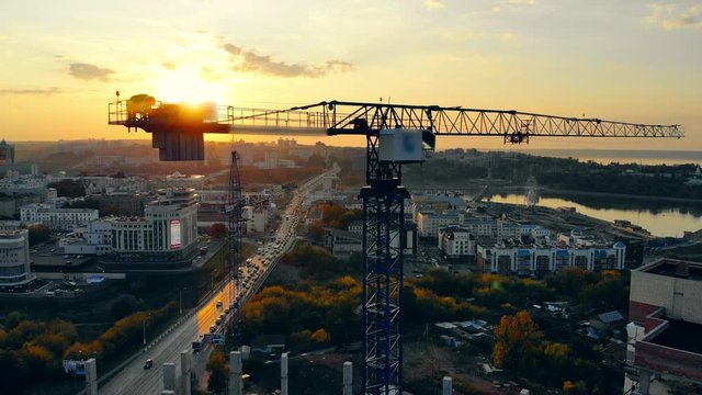 Big construction crane on sunset background.