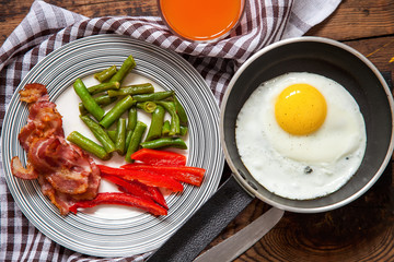 breakfast - fried eggs, siliculose haricot, bacon, a paprika and juice on a table, selective focus, top view, copy space
