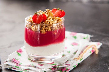 breakfast in a glass - yogurt, jam and muesli, selective focus, copy space