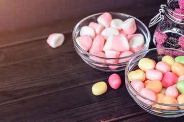 multi-colored candies in a plate, bank and bowls with copy space