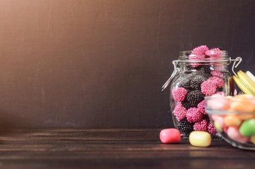 multi-colored candies in a plate, bank and bowls with copy space