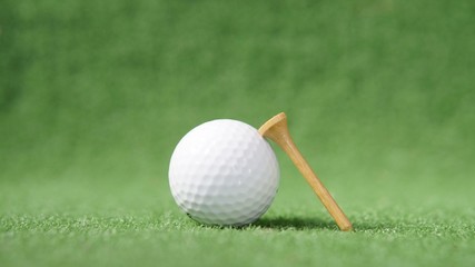 golf ball and tee on green grass