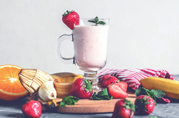 banana, strawberry and orange smoothies with mint on the table, front view