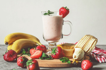 banana and strawberry smoothies with mint on the table, front view