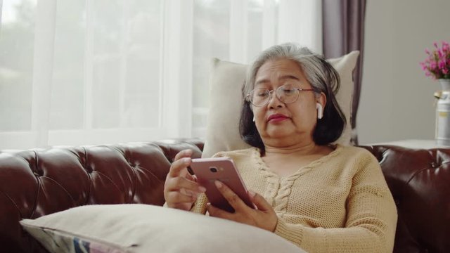 Senior woman doze asleep while listening music with smartphone