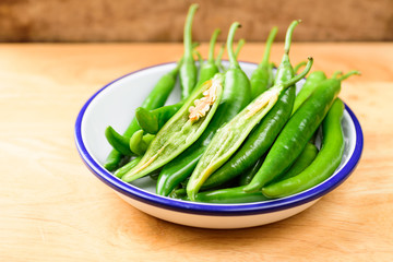 Green peppers for cooking on wooden background