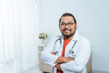 portrait of happy confident asian doctor smiling to camera