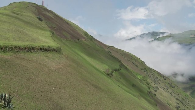 Ladera andina y al fondo cielo con nubes.