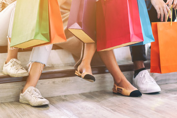 Closeup image of people holding shopping bags while sitting together