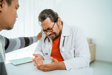Fototapeta premium stress doctor and patient try to comfort him. depress doctor of work pressure in office