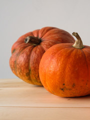 Halloween and Thanksgiving. Autumn concept. 2 orange pumpkins of different sizes on a wooden table. Autumn background. side view. Fall season.