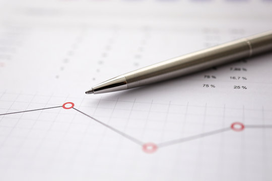 Business background chart with silver pen lie