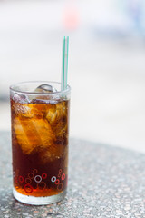 Cola in glass with ice on table