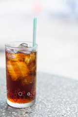 Cola in glass with ice on table