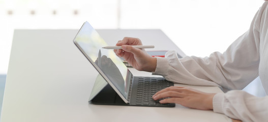 Cropped shot of young businesswoman working on her project while using tablet