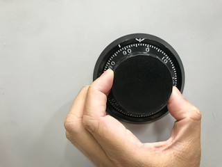 Hand is rotating the security code of safe