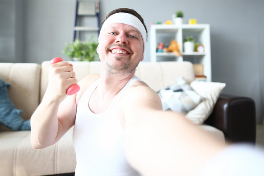 Cheerful Sportsman Doing Exercise with Dumbbell