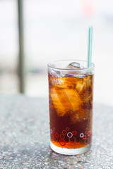 Cola in glass with ice on table