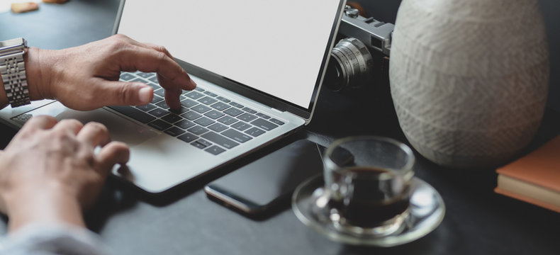 Cropped shot of businessman typing on laptop computer while working on his project