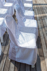 Fototapeta na wymiar Row of chairs with white fabric covers