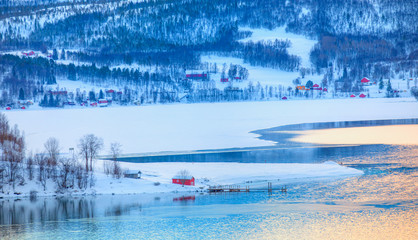 Beautiful landscape cracking ice, frozen norwegian sea coast at sunrise - Tromso, Norway