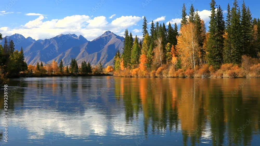 Wall mural tranquil autumn landscape with a reflection of yellowed trees and a mountain range in the irkut rive