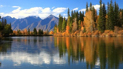 Tranquil autumn landscape with a reflection of yellowed trees and a mountain range in the Irkut River on a sunny day. Siberia, Baikal region, Eastern Sayan Mountains, Buryatia, Tunka valley - Powered by Adobe