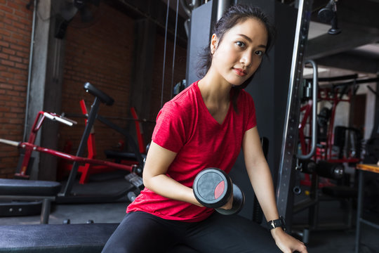 Picture cute of a smile asian woman exercising building muscles in the gym, concept of healthy lifestyle