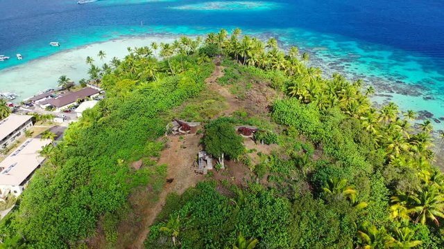 Aerial of two deactivated World War II cannons on a beautiful tropical island, drone flying forward then tilting down over the cannons - Bora Bora, French Polynesia