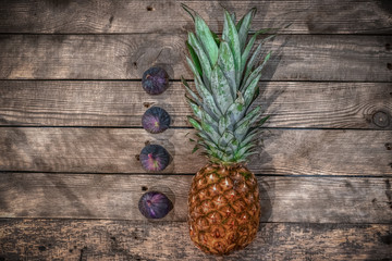 pineapple and figs on a wooden table