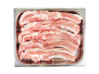 Pieces of fresh pork meat in a metal tray isolated on white background. View from above