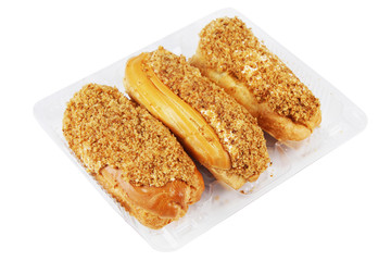 Three custard eclairs in a plastic container isolated on white background