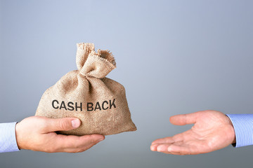 Mans hand holding, giving bag with cash bag. Cash back or money refund concept.
