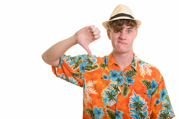 Stressed young tourist man with hat giving thumbs down for vacation