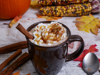 Brown cup with whipped cream, caramel syrup and sprinkles
