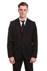 Young handsome blonde businessman in suit looking at camera