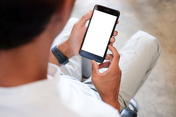 Mock up smartphone of hand holding black mobile phone with blank white screen.