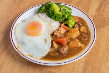 Chicken curry Rice on wooden background ( Poached egg, Potato, enoki mushroom, onion, broccoli, Japanese style,)