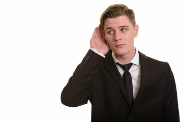 Young handsome blonde businessman in suit listening