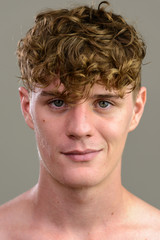 Face of young handsome man with curly blond hair shirtless