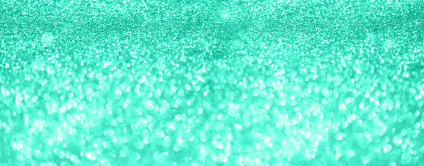 Obraz premium Gold glitter banner. Shiny abstract textured background with golden lights, bokeh. Trendy green and turquoise color. Christmas, new year conceptin mint color